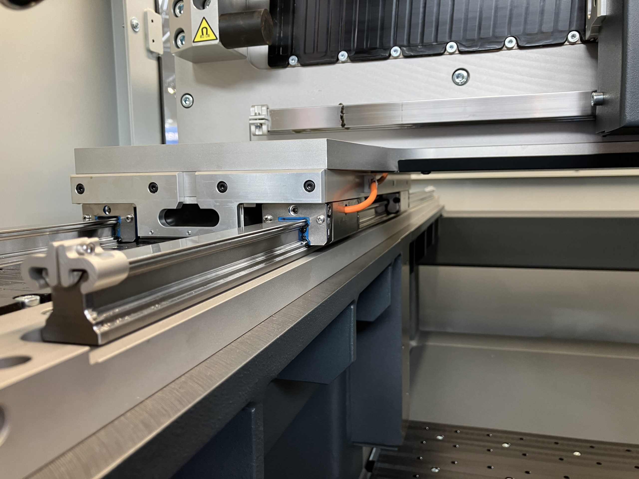 Oś liniowa maszyny laserowej Battery Welder z precyzyjną prowadnicą kulkową BSHP i zintegrowanym systemem pomiaru przemieszczenia IMScompact jako enkoderem liniowym. (Źr&oacute;dło obrazu: Bosch Rexroth AG)