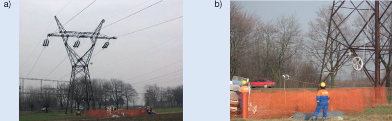 Rys. 3. Przykład ekwipotencjalnego stanowiska maszyn do wymiany przewod&oacute;w brygady Eltel:  a) og&oacute;lny widok stanowiska, b) fragment z uziemiaczem przesuwnym i rolką kierunkową