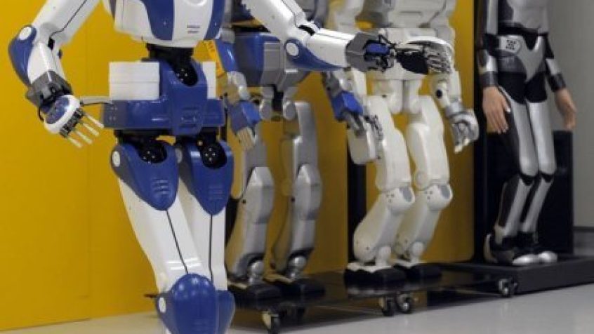 Robot HRP-4 spaceruje przy swoich poprzednich wersjach na konferencji w Tsakuba w Japonii.