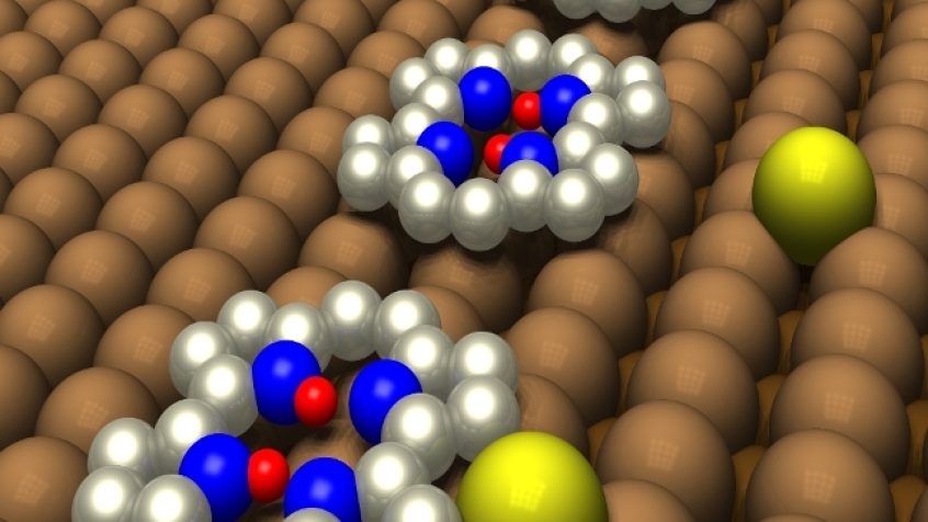 Dwa protony (czerwony) w cząsteczce porficenu osadzonej na powierzchni idealnego kryształu miedzi (brązowy) zmieniają położenie przy atomach azotu (niebieski) w zależności od położenia pojedynczego atomu miedzi (żółty).
